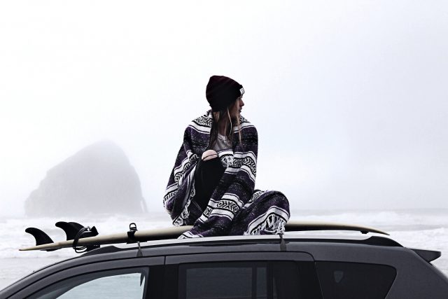 Woman sitting on top of a car